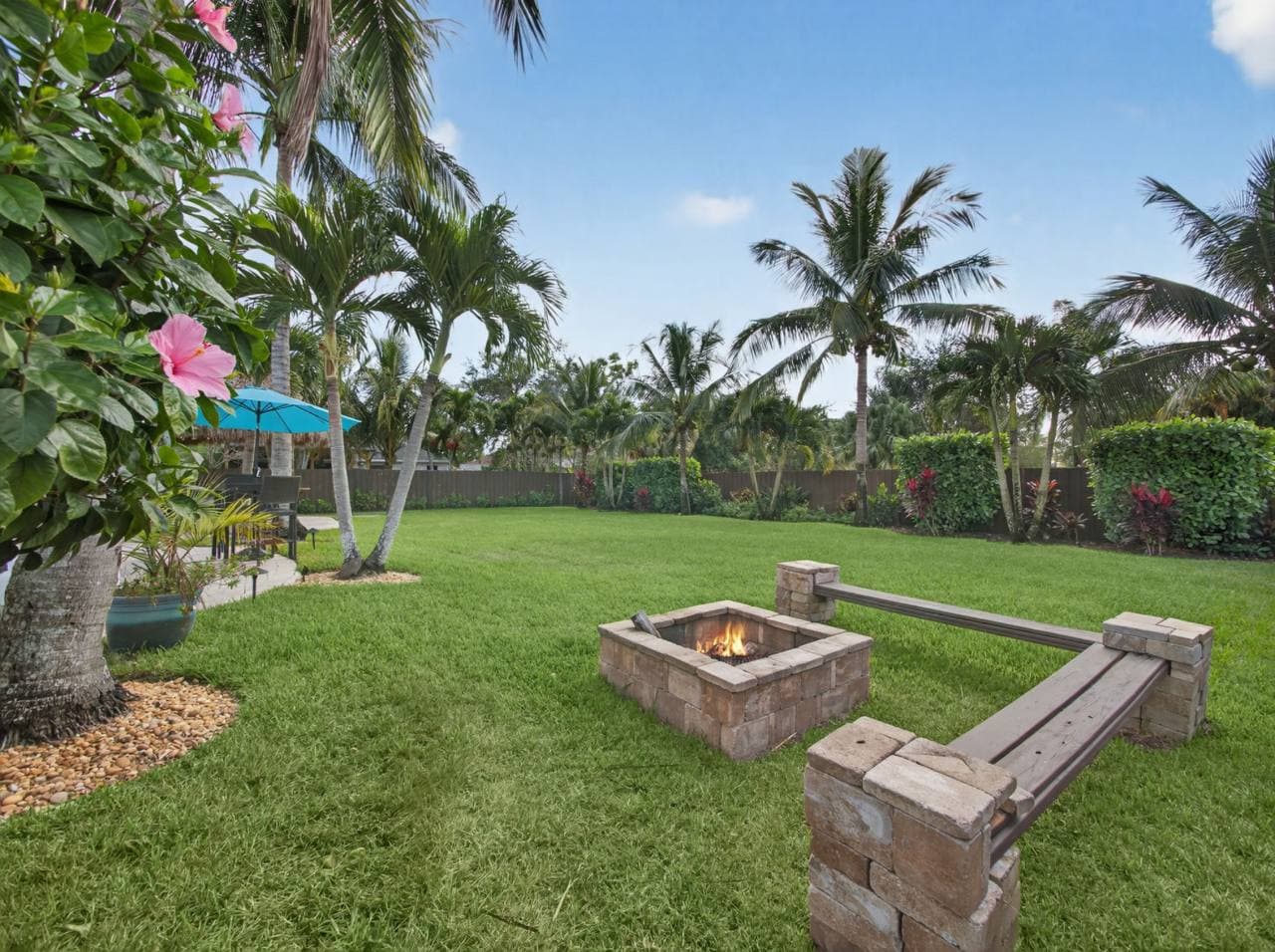 Fire pit with stone benches and tropical landscaping