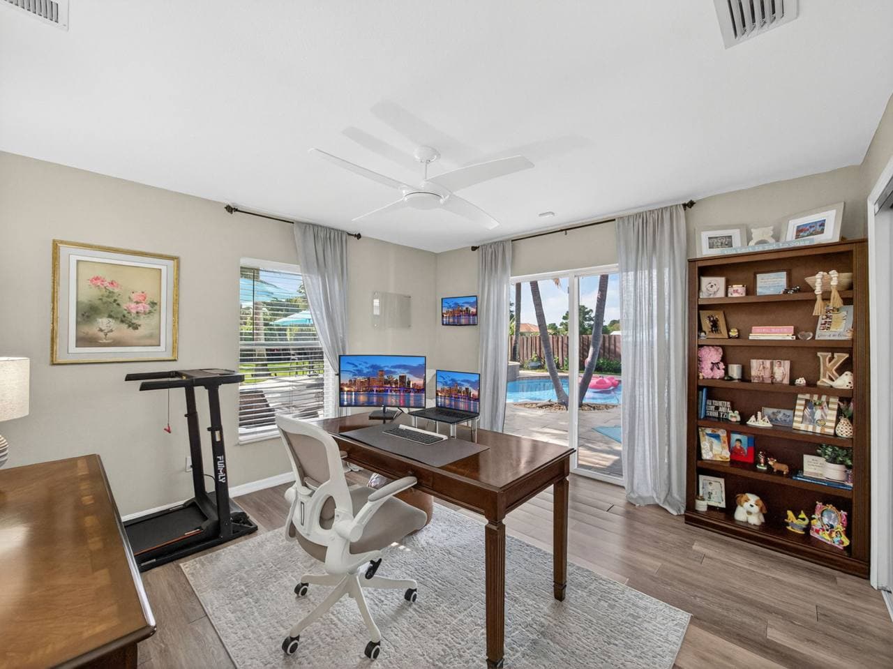 Home office with dual monitors and pool view