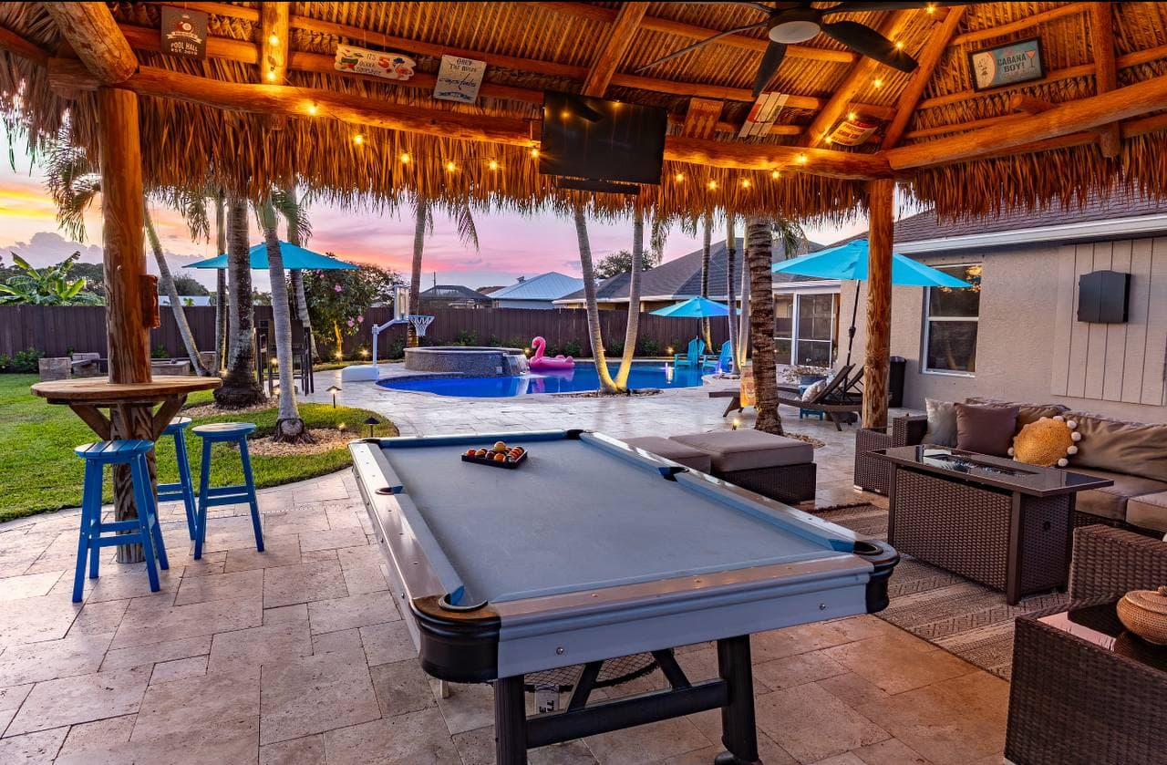 Tiki hut with fire table and string lights at night